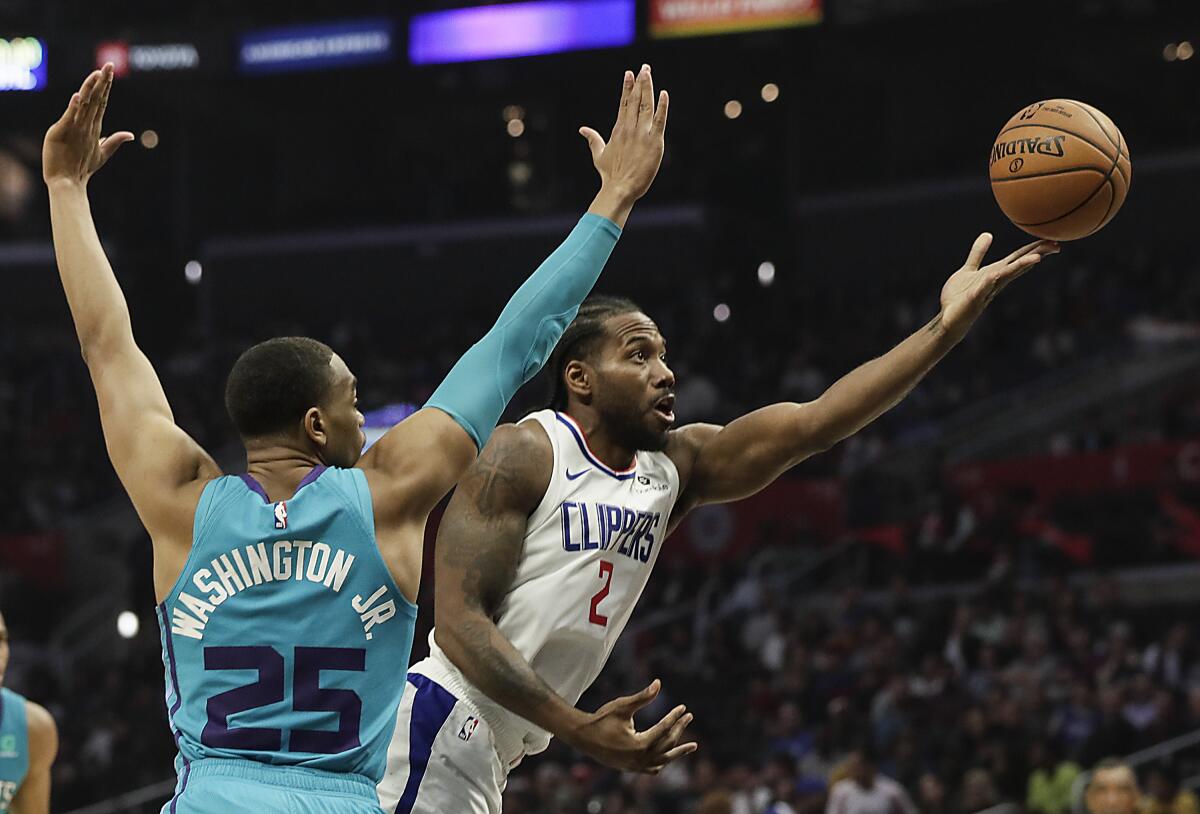 Clippers forward Kawhi Leonard scoops a shot past Charlotte Hornets forward PJ Washington.