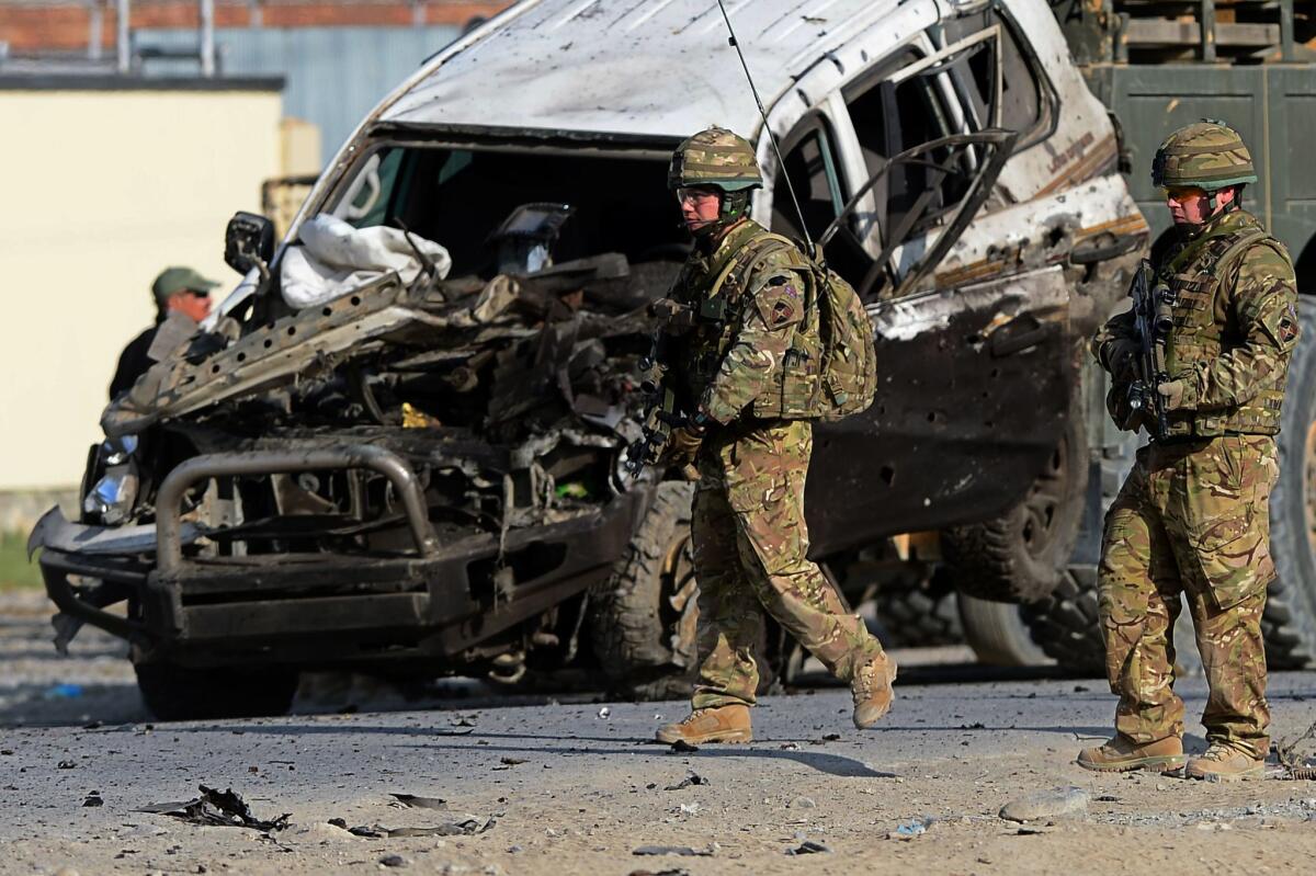 U.S. soldiers at the site of a suicide attack as a vehicle pulls the wreckage of a damaged car in Kabul on Oct. 13.