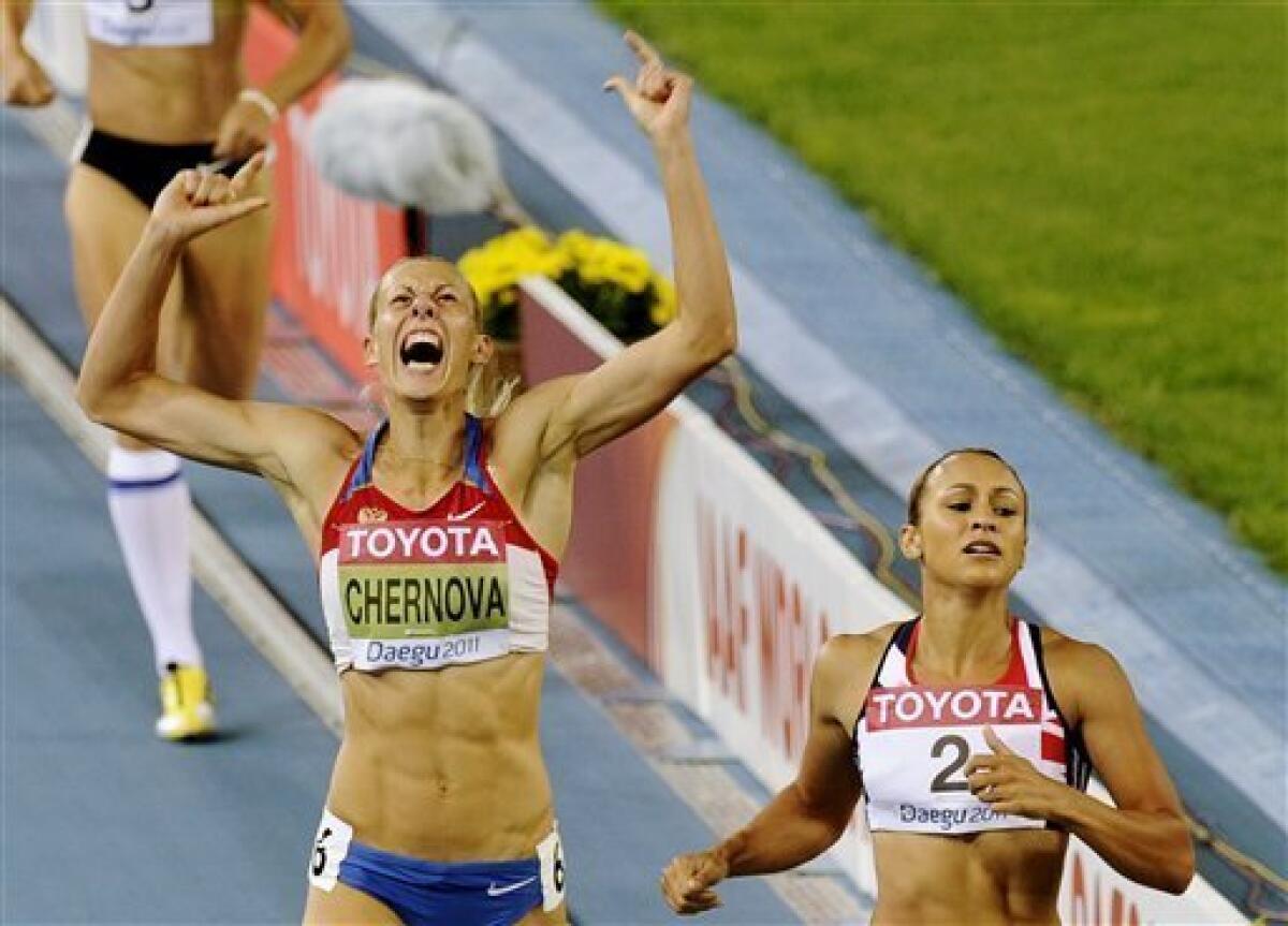 Russia's Tatyana Chernova, left, reacts as she goes to cross the finish line with Britain's Jessica Ennis in the Heptathlon 800m at the World Athletics Championships in Daegu, South Korea, Tuesday, Aug. 30, 2011. (AP Photo/Martin Meissner)