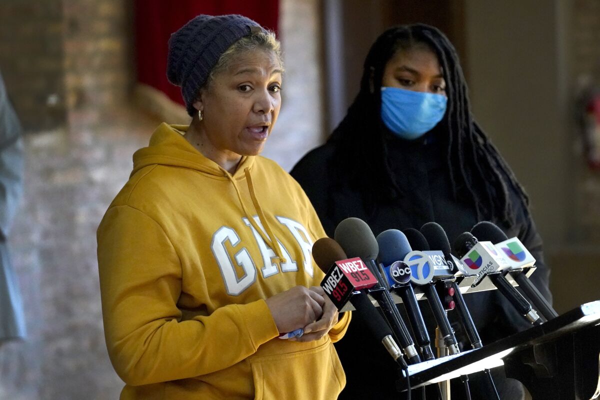 Cheri Warner, left, stands with her daughter, Brea, and speaks calling for the Chicago school district and teacher's union to focus on getting students back in the classroom Monday, Jan. 10, 2022, in Chicago. Hundreds of thousands of Chicago students remained out of school for a fourth day Monday, after leaders of the nation's third-largest school district failed to resolve a deepening clash with the influential teachers union over COVID-19 safety protocols. (AP Photo/Charles Rex Arbogast)