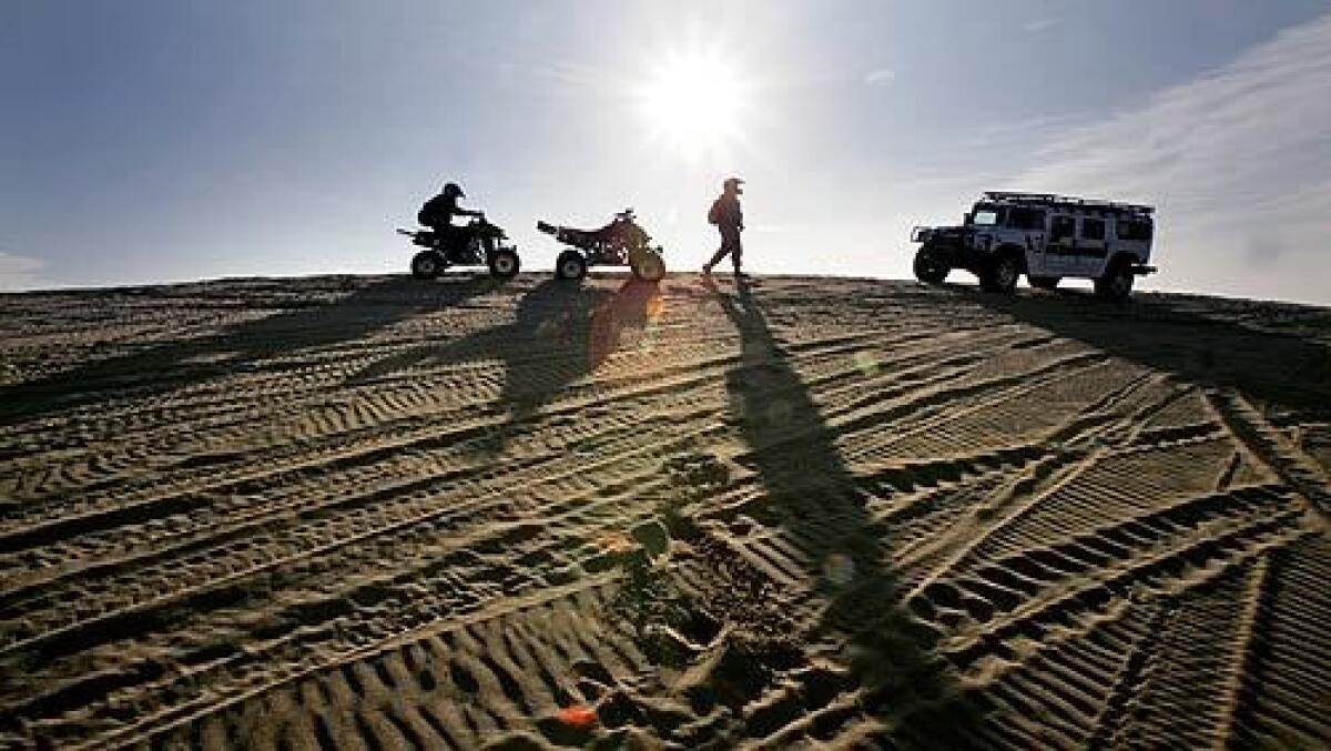 U.S. Border Patrol agents on small ATVs stop to talk with another agent in a Hummer in the Imperial Sand Dunes Recreation Area. It's a 24-hour-a-day enforcement effort to keep smugglers from crossing the unfenced desert borderline.