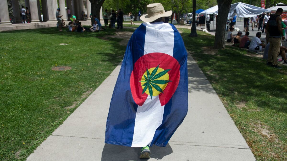 A marcher at a rally in Denver modified the Colorado state flag to show his support for legalizing marijuana.