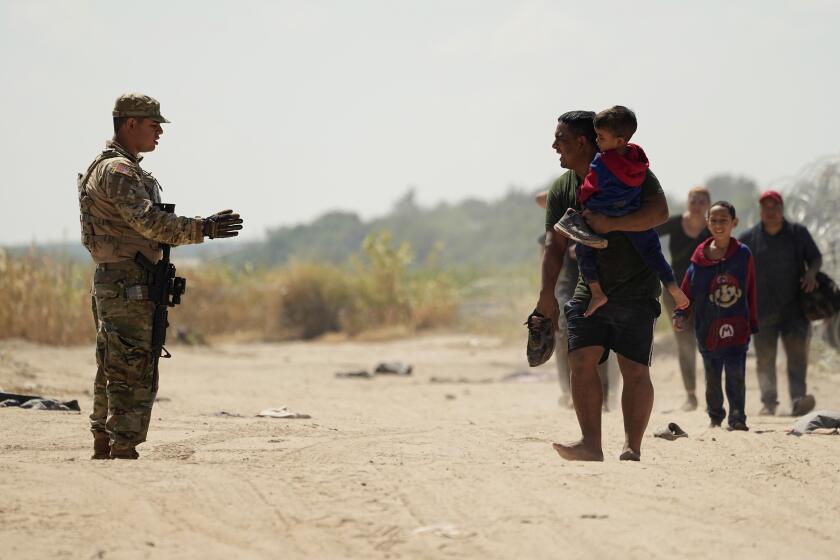 Migrants who crossed the Rio Grande river to the U.S. from Mexico seek direction from a guardsman, Friday, Sept. 22, 2023, in Eagle Pass, Texas. (AP Photo/Eric Gay)