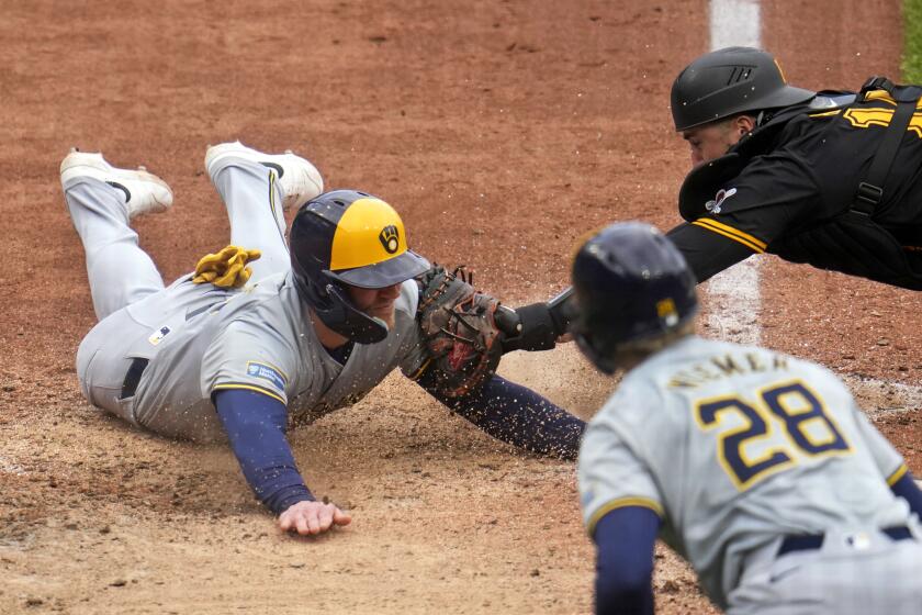 Pittsburgh Pirates catcher Joey Bart, top right, tags out Milwaukee Brewers' Jake Bauers, left, who was attempting to score on a fielder's choice by Blake Perkins, during the ninth inning of a baseball game in Pittsburgh, Thursday, April 25, 2024. The Brewers won 7-5. (AP Photo/Gene J. Puskar)