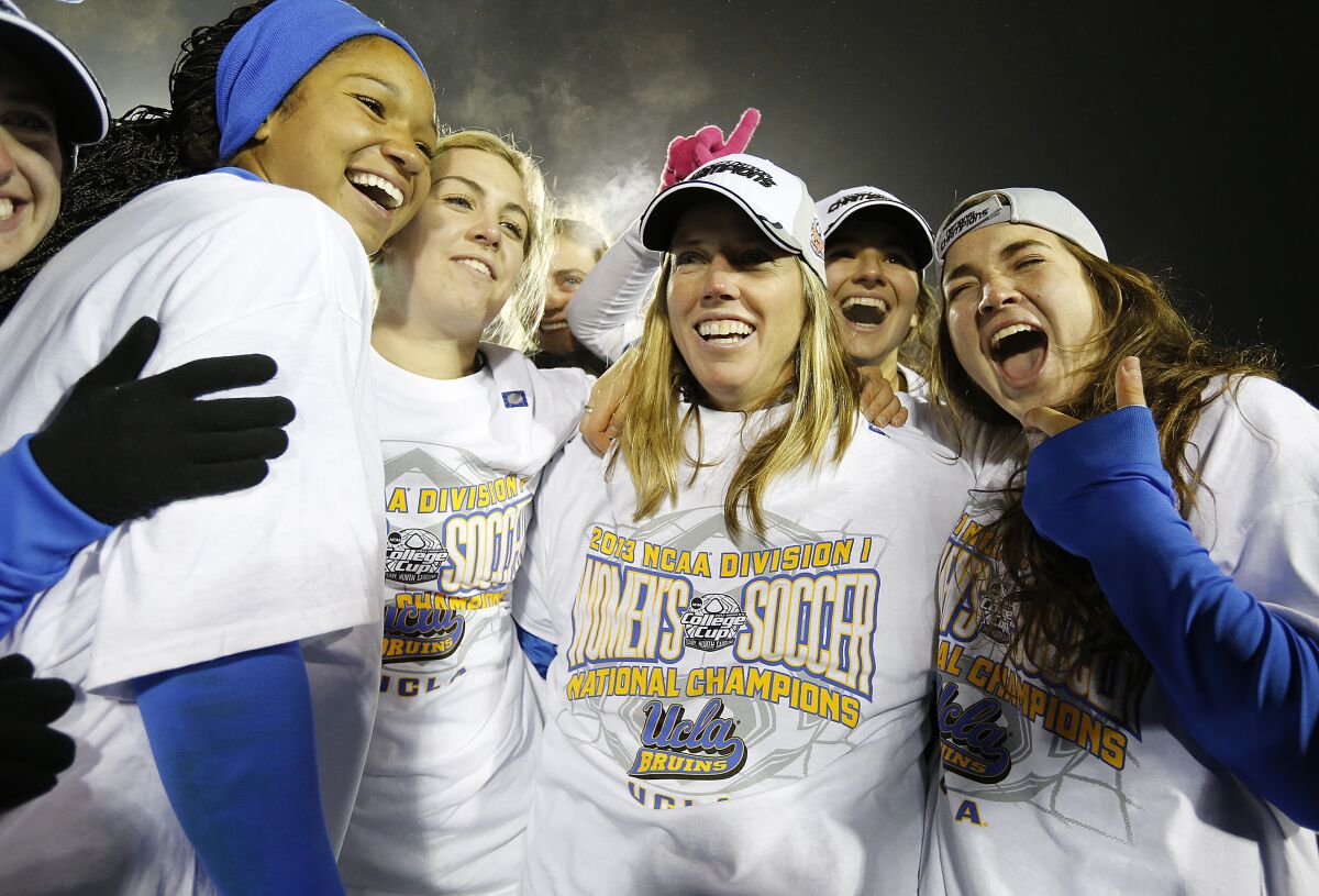 UCLA players celebrate with head coach Amanda Cromwell, center, after beating Florida State to win a national championship 