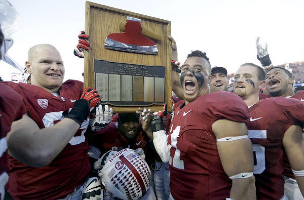 Stanford defensive lineman Trent Murphy (93) and linebacker Shayne Skov (11) celebrate with the Stanford Axe after beating California in the annual Bay Area rivalry game.