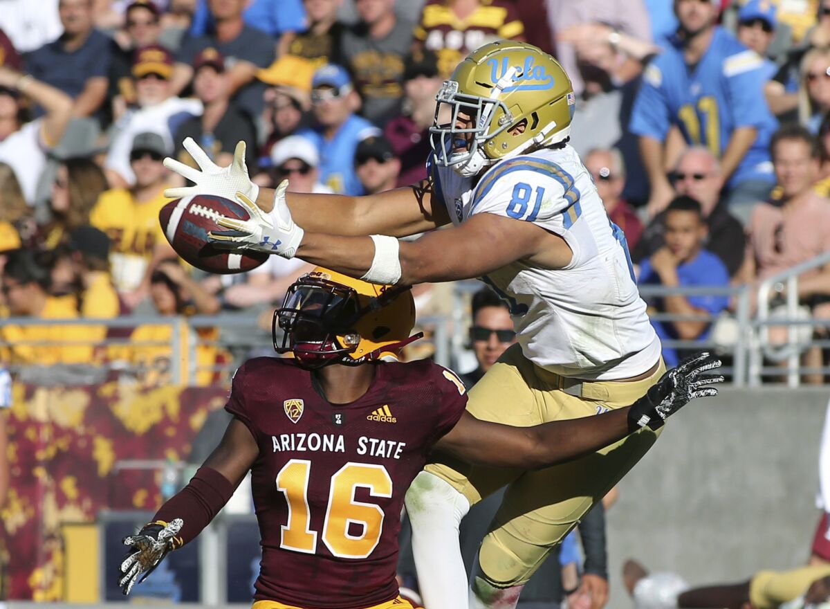 UCLA tight end Caleb Wilson leaps to catch a pass over Arizona State defensive back Aashari Crosswell during a game Nov. 10.