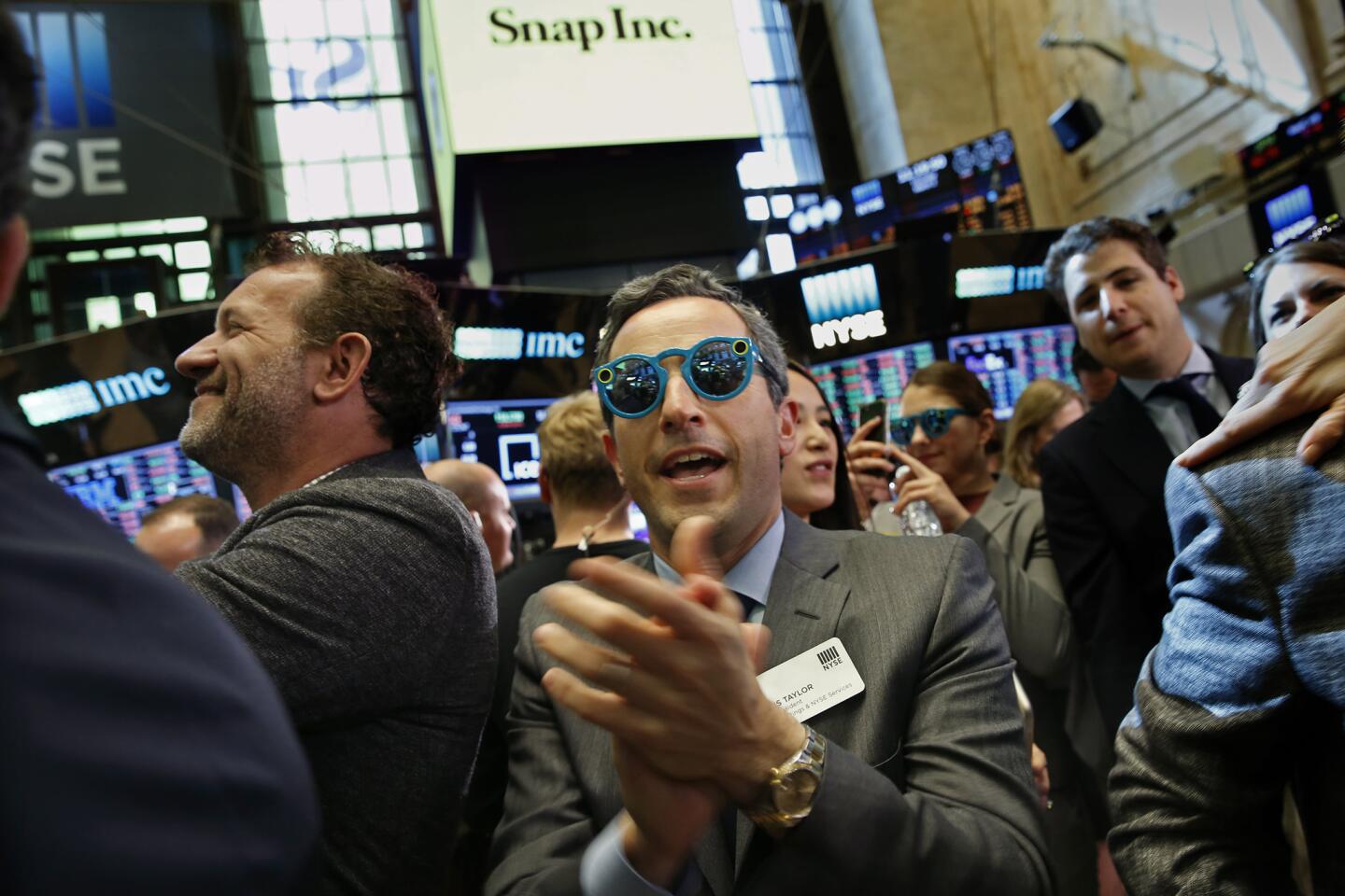 Wearing glasses by Snap, Chris Taylor, Vice President of the NYSE Listings an NYSE Services and others celebrate the listing of Snap Inc. on the New York Stock Exchange.
