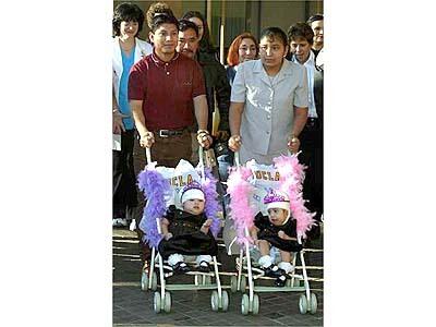 Maria de Jesus, right, and Maria Teresa are pushed in strollers by their Mother Alba Leticia Alvarez and Father Wenceslao Quiej Lopez on their way to a press conference announcing their departure to Guatemala.