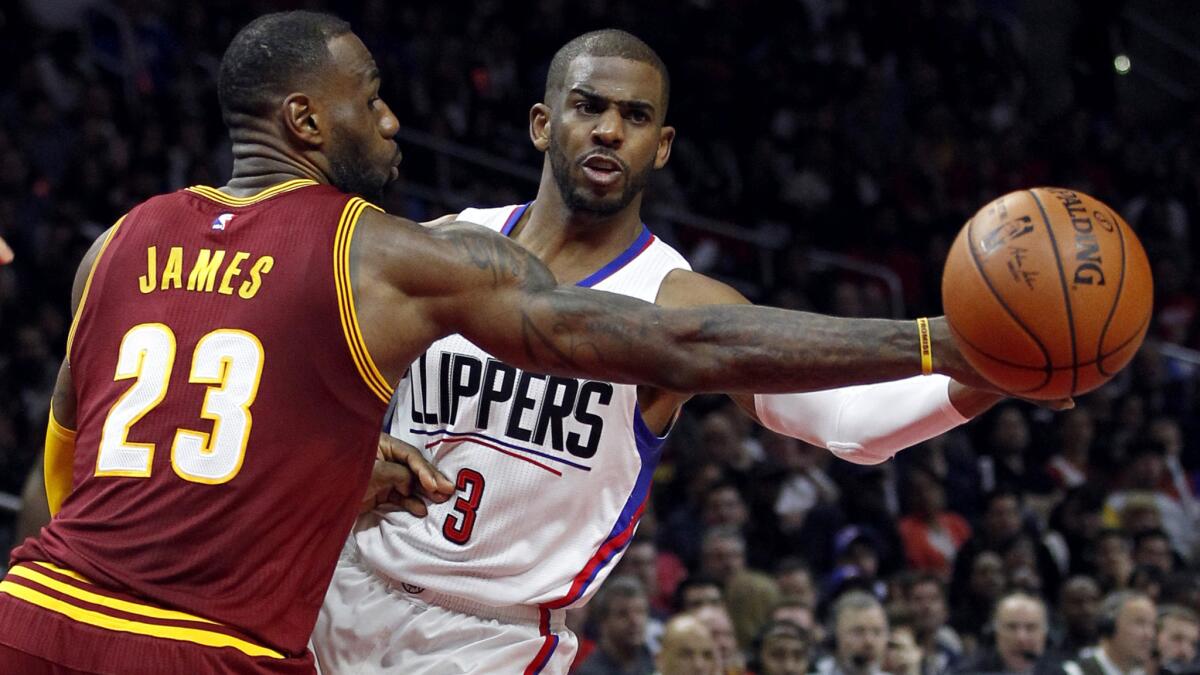 Clippers guard Chris Paul slips a pass around Cavaliers forward LeBron James during the first half Sunday.