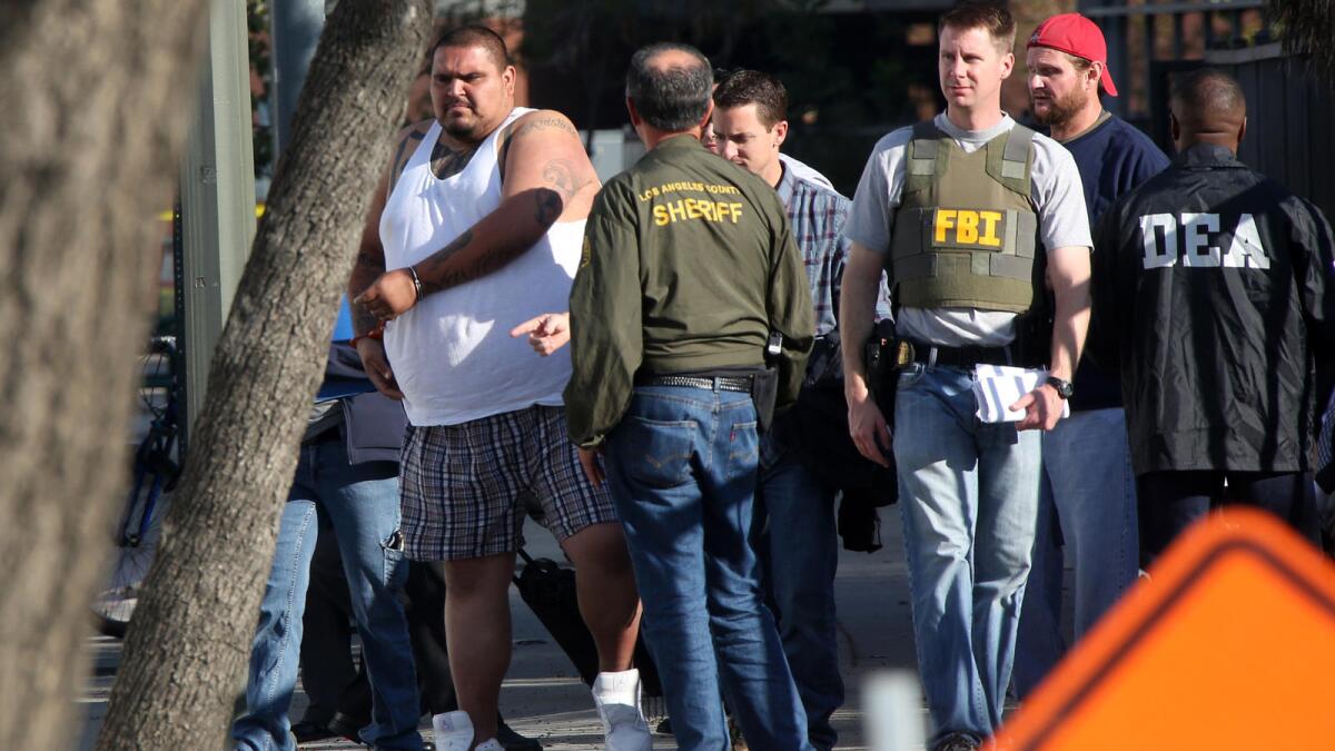 A suspect is processed in downtown Los Angeles in 2016 as authorities rounded up members of the Big Hazard gang indicted under federal RICO statutes.