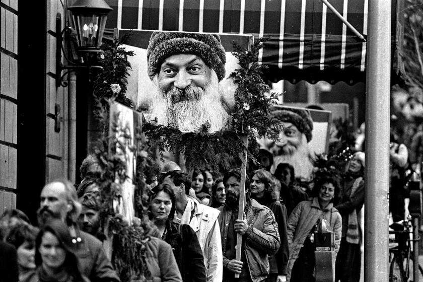 About 250 followers of the Bhagwan Shree Rajneesh, many carrying posters of the guru, march in a peaceful demonstration in downtown Portland, Ore., Friday, Nov. 1, 1985. They are protesting the incarceration of their guru in Charlotte, North Carolina. (AP Photo/Jack Smith)