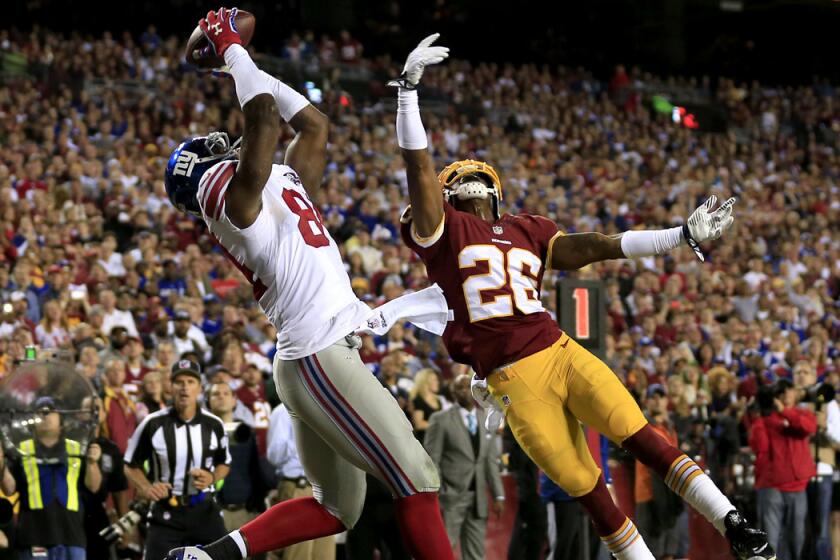 Giants tight end Larry Donnell leaps above the outstretched arm of Redskins cornerback Bashaud Breeland to make a touchdown catch in the second quarter Thursday night.