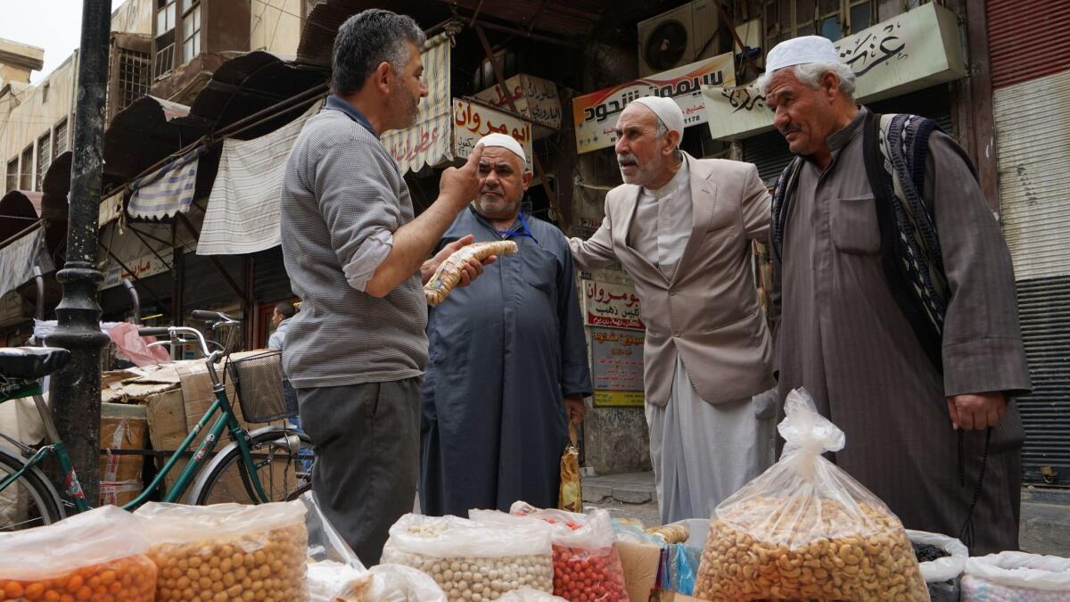 Mahal Ghanem, left, sells nuts, chips and other snacks in Damascus' Old City. He says he believes the United States is working with Islamic State.