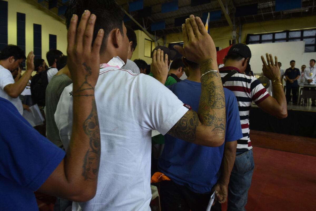 Drug users and dealers take an oath on July 18 after they voluntarily surrendered to authorities in Tanauan town, Batangas province, south of Manila.