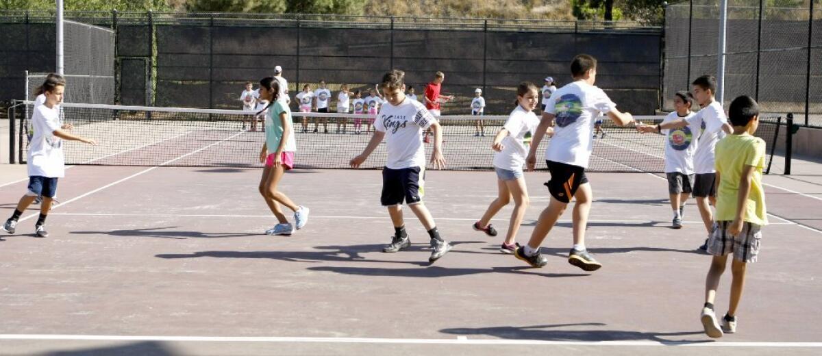Young tennis players warm up on the last day of the LA84 Foundation Tennis Camp at Scholl Canyon Tennis Center in Glendale on Thursday.