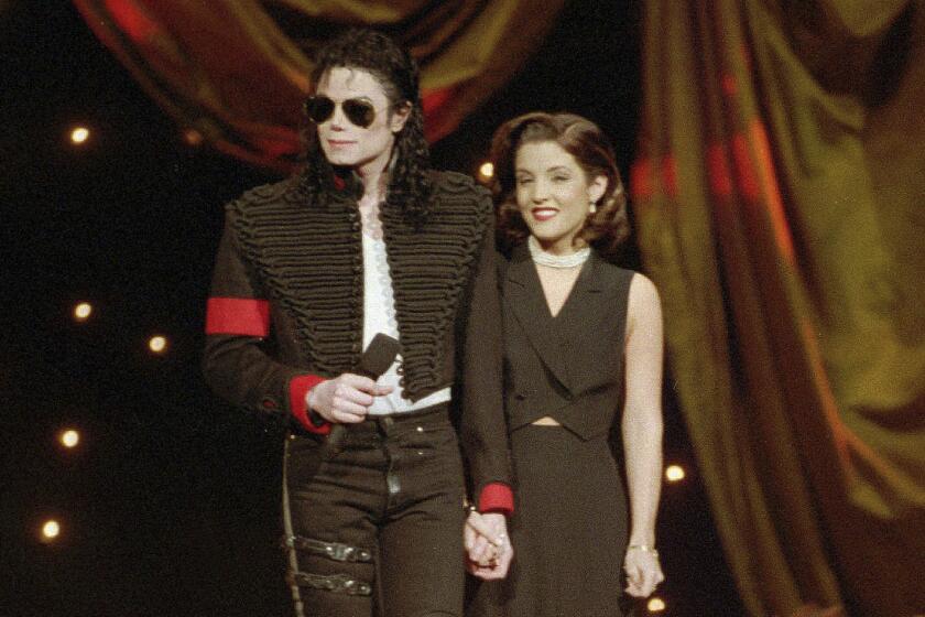 Michael Jackson holding hands with Lisa Marie Presley onstage at an awards shoes