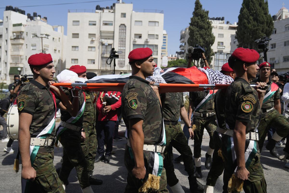 A Palestinian honor guard carries the body of Aysenur Ezgi Eygi in a funeral procession in the West Bank city of Nablus.