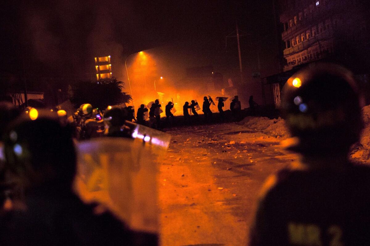 Cambodian police in riot gear stand guard Friday during a garment workers' protest in Phnom Penh. Cambodian human rights advocates say at least four protesters were killed when troops fired on the crowds of workers on strike for higher wages.