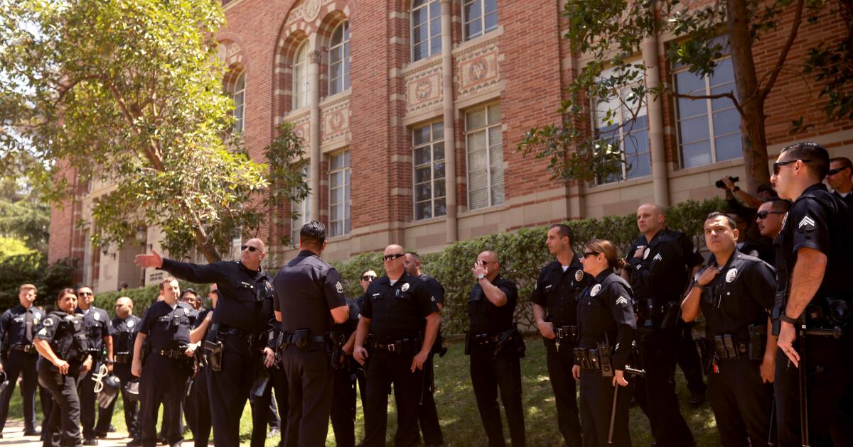 LOS ANGELES, CA - MAY 1, 2024 - Campus police confer while posting yards away from the pro-Palestinian camp on the UCLA campus on May 1, 2024. (Genaro Molina/Los Angeles Times)