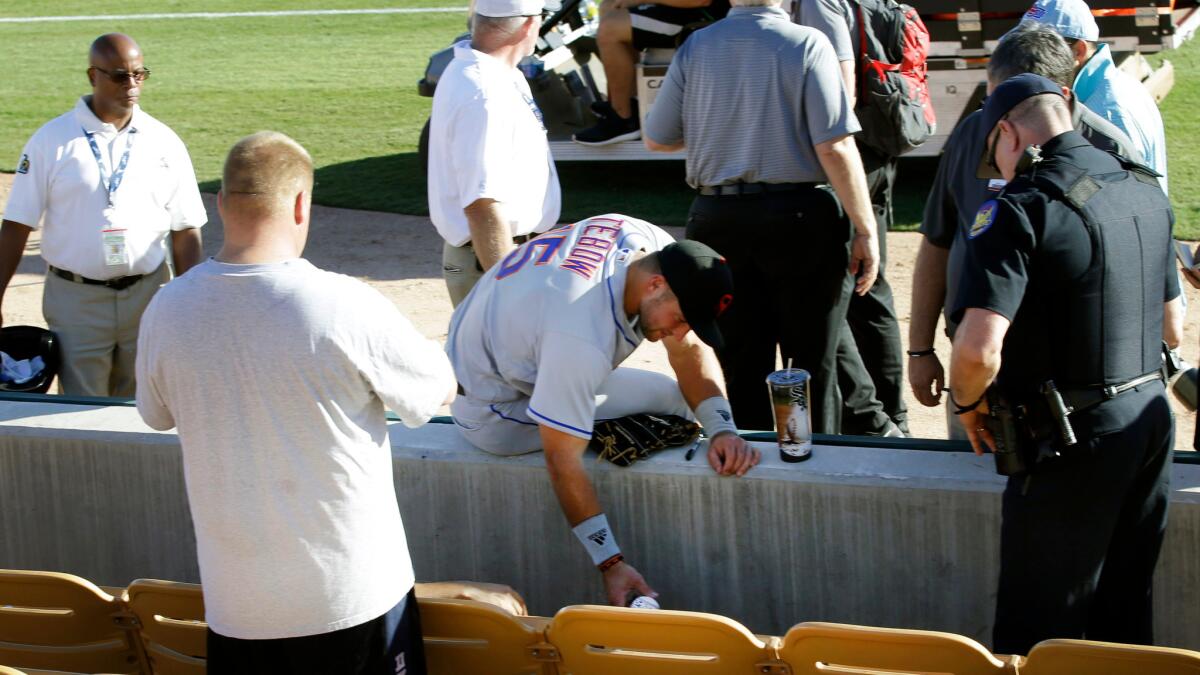 Tim Tebow comforts a fan who had a seizure at an Arizona Fall League baseball game on Tuesday.