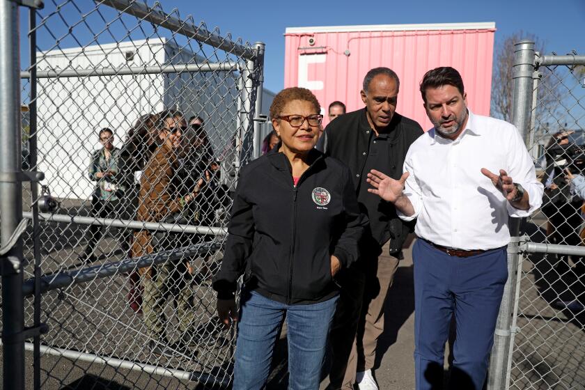 LOS ANGELES, CA - FEBRUARY 07: Mayor of Los Angeles Karen Bass, left, Kevin Murray, with Weingart, and Jeff Olivet, the executive director of the United States Council on Homelessness, tour the Hilda Solis Care First Village to see the 232 interim housing rooms built from shipping containers and prefabricated modular units in downtown on Tuesday, Feb. 7, 2023 in Los Angeles, CA. Mayor of Los Angeles Karen Bass spent the day with Jeff Olivet, the executive director of the United States Council on Homelessness. (Gary Coronado / Los Angeles Times)