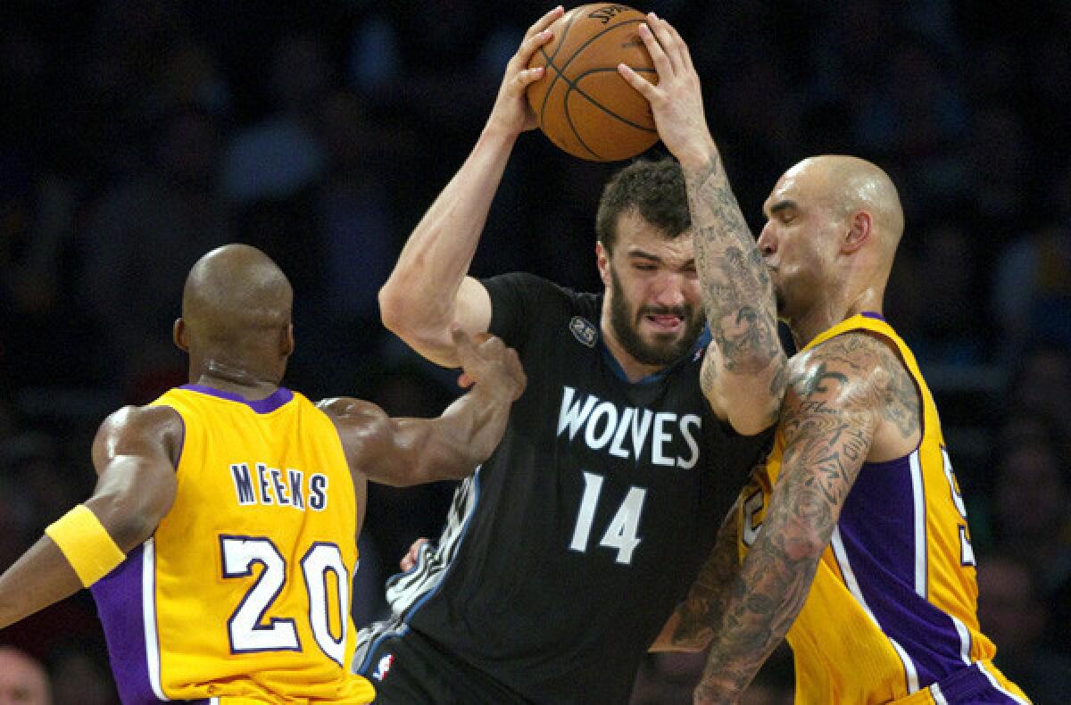 Timberwolves center Nikola Pekovic tries to power his way to the basket against Lakers guard Jodie Meeks center Robert Sacre during a game earlier this season at Staples Center.