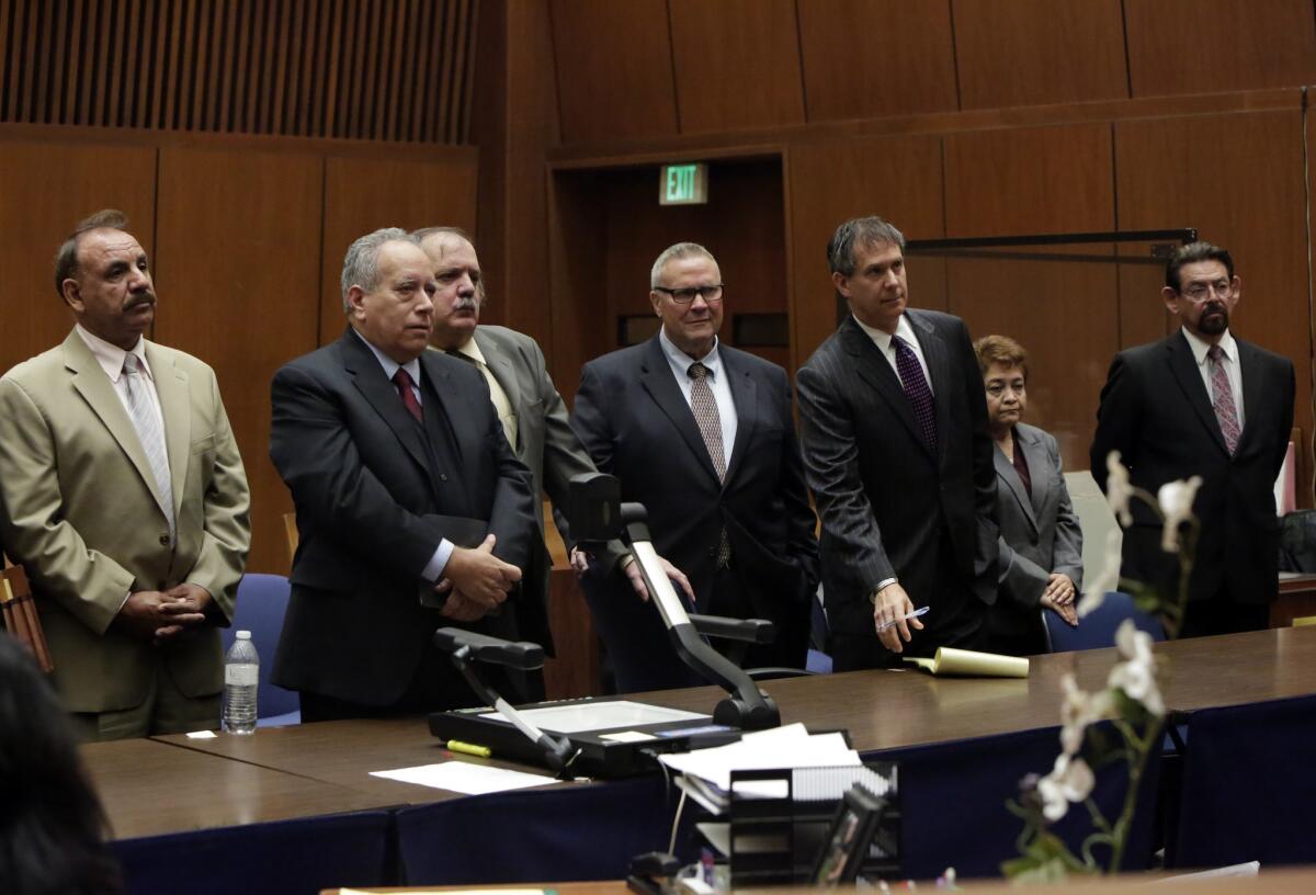 A defense attorney (second from left) stands with former Bell City Council members Oscar Hernandez, left, Victor Bello, George Cole, Teresa Jacobo and George Mirabal in February.