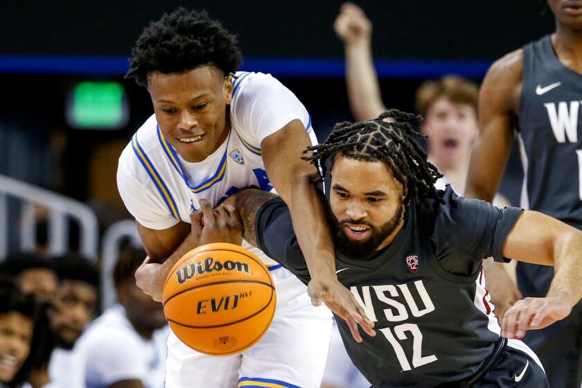 UCLA guard Jaylen Clark, left, and Washington State guard Michael Flowers compete for the ball during the first half of an NCAA college basketball game Thursday, Feb. 17, 2022, in Los Angeles. (AP Photo/Ringo H.W. Chiu)
