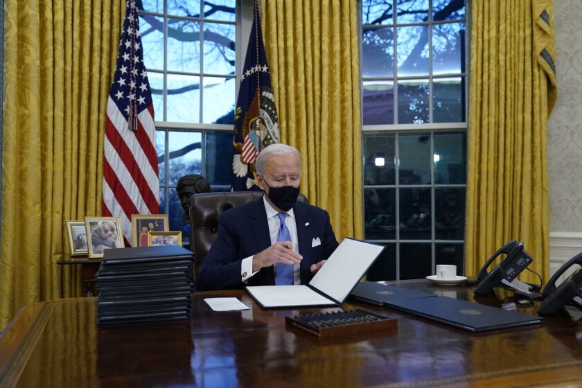 El presidente Joe Biden firma sus primeros decretos en la Oficina Oval de la Casa Blanca, el miércoles 20 de enero 2021, en Washington. (AP Foto/Evan Vucci)