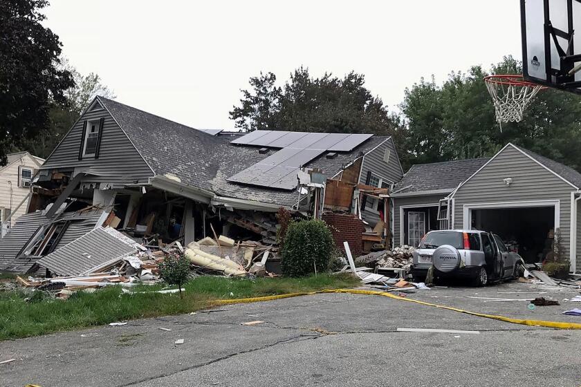 ADDS IDENITY OF VICTIM LEONEL RONDON- A collapsed home and car sit damaged on Chickering Street in Lawrence, Mass., Thursday, Sept. 13, 2018, after a series of gas explosions in several communities north of Boston. Authorities said Leonel Rondon died after the chimney toppled by the exploding house crashed into his car in the driveway. He was rushed to a Boston hospital but pronounced dead there in the evening. (Carl Russo/The Eagle-Tribune via AP)