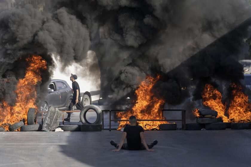 Neumáticos prendidos por palestinos queman en el lugar donde dos palestinos murieron baleados por el ejército israelí en el campo de refugiados de Jalazone cerca de la ciudad de Ramala, Cisjordania, el lunes 3 de octubre de lunes de 2022.. (AP Foto/Majdi Mohammed)