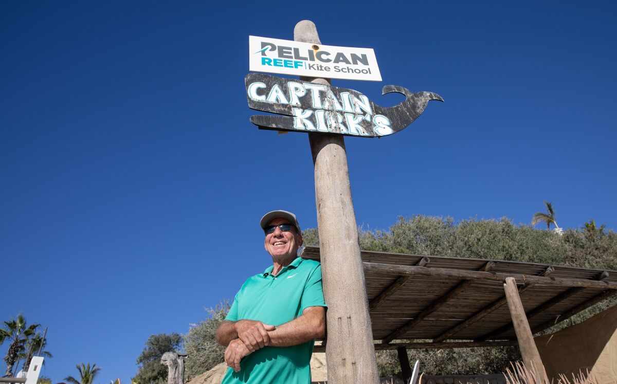 A man stands next to a sign reading "Captain Kirk's"