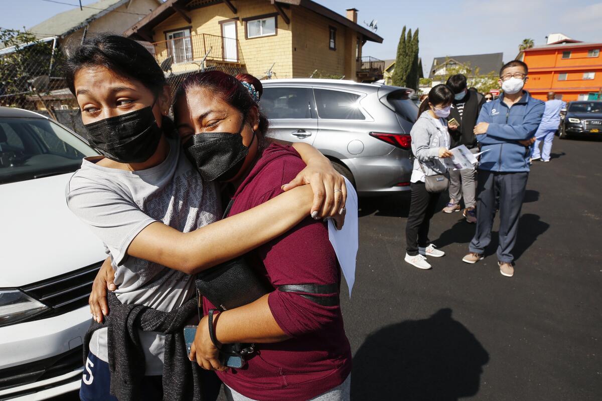 Jeymy Mendoza, 16, hugs her mother, Maria Jimenez, 34, at a mobile COVID-19 vaccine clinic in Los Angeles.
