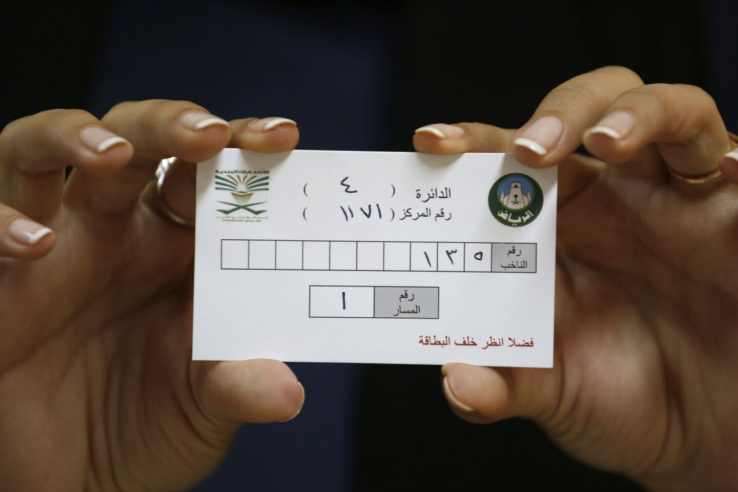 A woman proudly holds her voter identification card at a polling station in Riyadh. Of the 1.5 million registered voters in Saudi Arabia, only 130,000 are women.