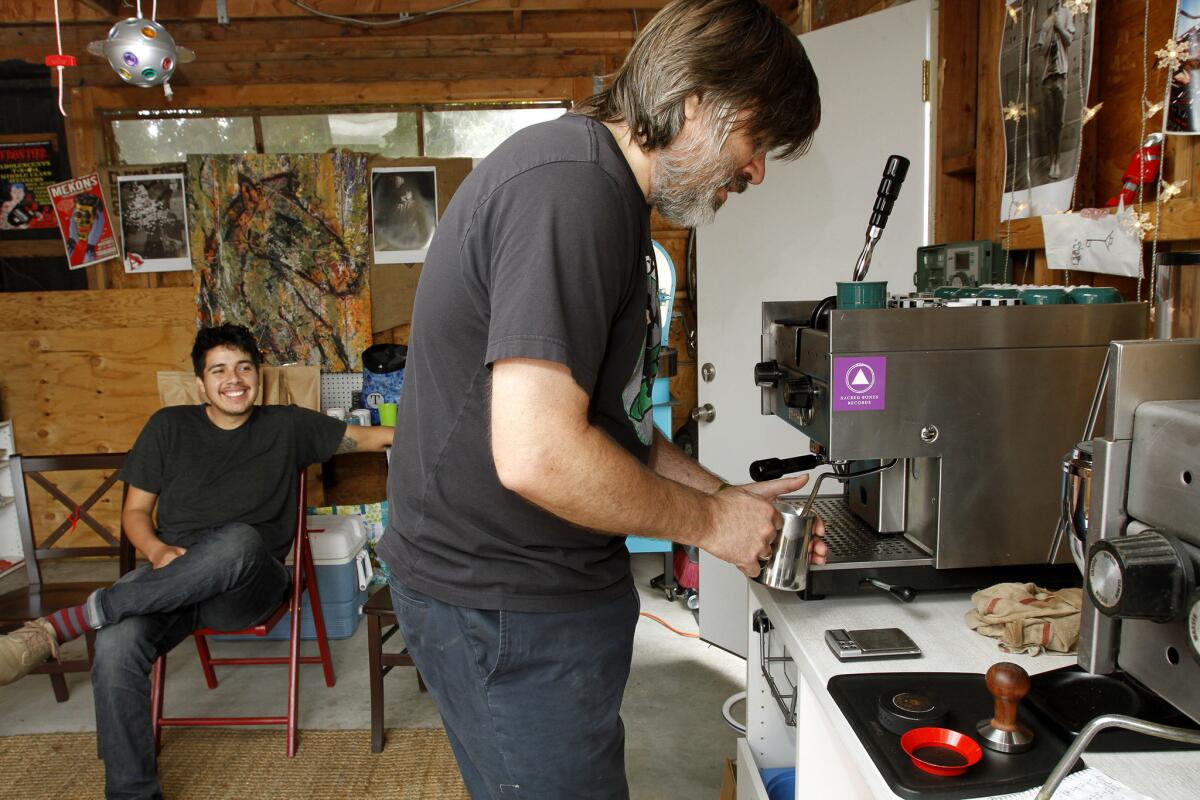 Trystero Coffee roasting company owner Greg Thomas, right, makes a coffee drink for friend and customer Andres Tena of L.A., left, at Thomas' home office in the Atwatyer Village area of Los Angeles on Saturday, March 22, 2014. Thomas recently roasted his 2,500 batch of coffee, which he sells over the internet and from his garage. (Raul Roa/Staff Photographer)