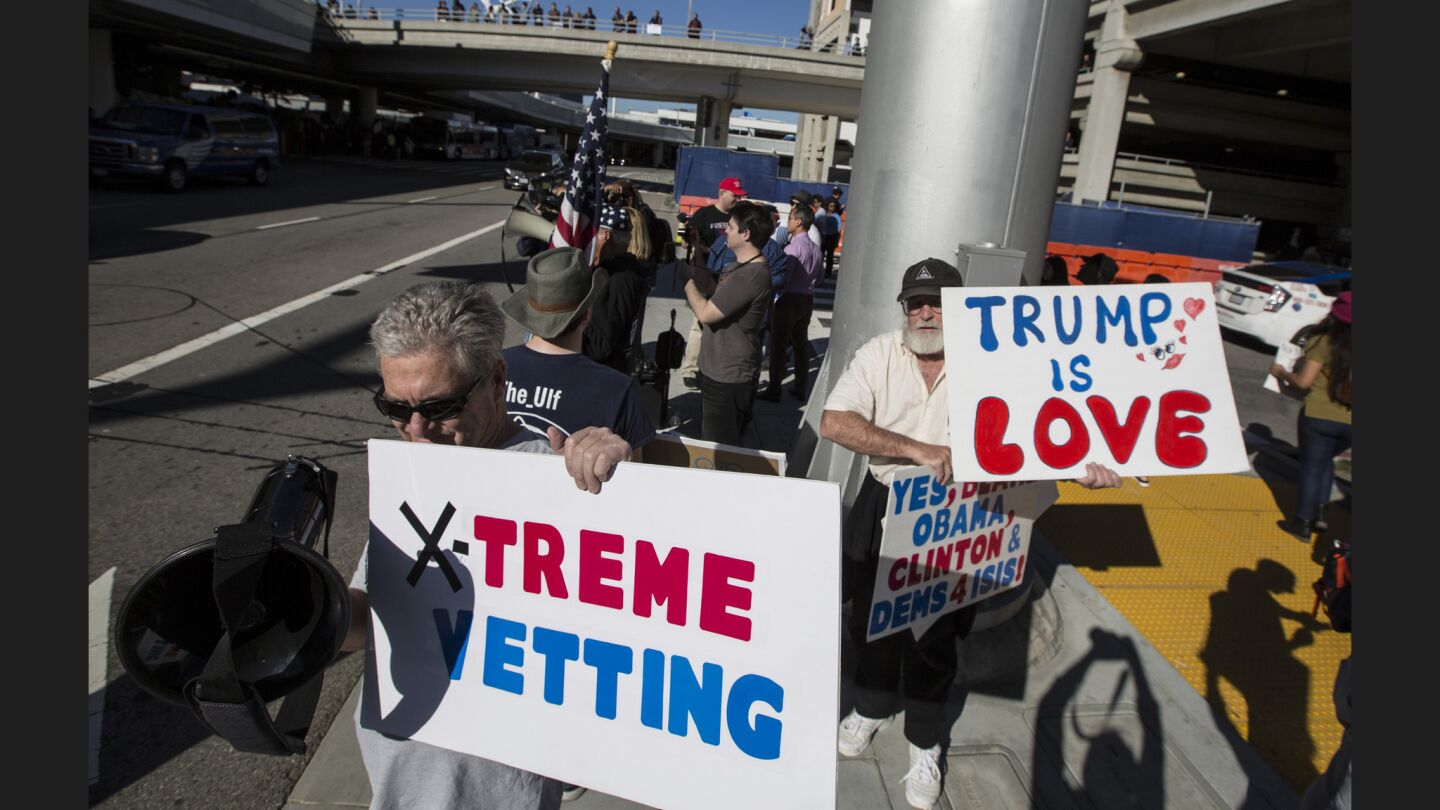 Donald Trump supporters hold signs across the road from protesters at Tom Bradley International Terminal.