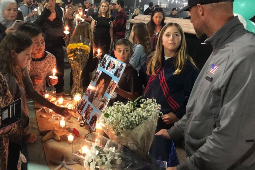 A crowd assembles for Saturday night's vigil at Pier Plaza for Huntington Beach resident Christina Mauser, who died in last weekend's helicopter crash in Calabasas that also killed Kobe Bryant and seven other local residents.