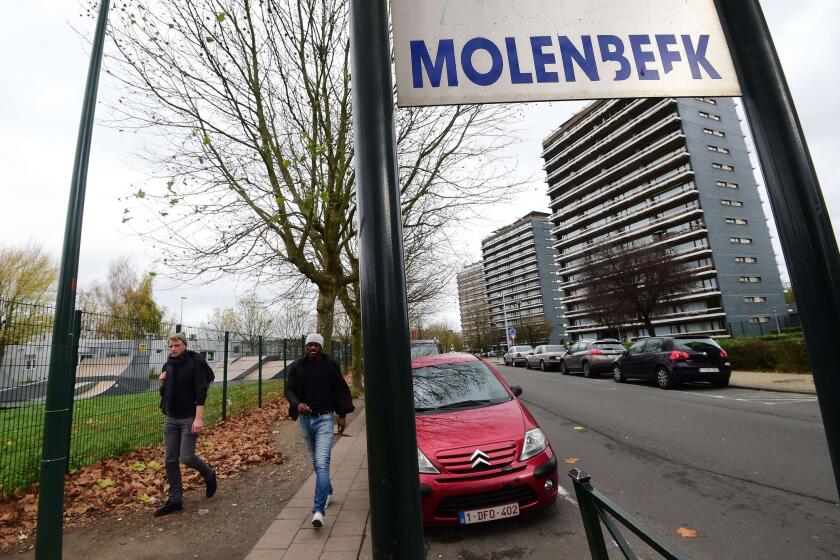 People make their way in Brussels' Molenbeek suburb, near where police made arrests Nov. 15 in connection with the deadly attacks in Paris.