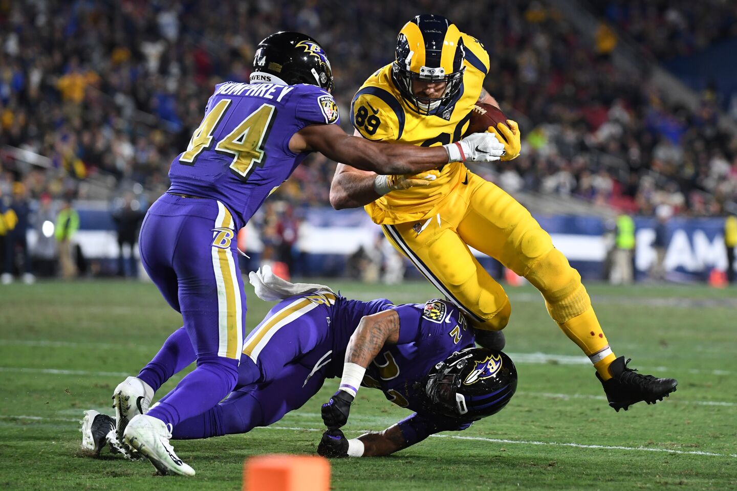 Rams tight end Tyler Higbee is stopped short of the goal line by Ravens cornerbacks Marlon Humphrey (44) and Jimmy Smith during the second quarter of a game Nov. 25 at the Coliseum.