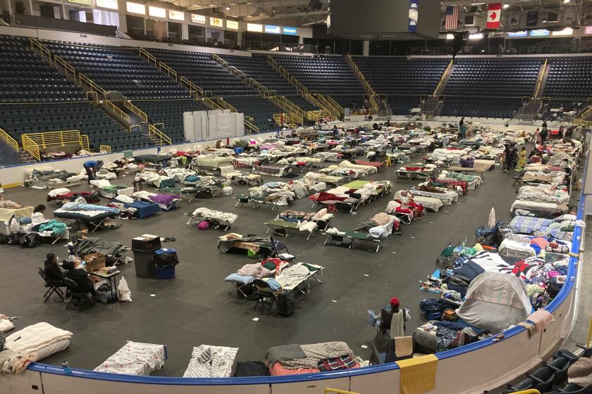 Cots cover the floor of Hertz Arena, an ice hockey venue that has been transformed into a massive relief shelter, in Estero, Fla., on Saturday, Oct. 8, 2022. More than 500 people were still housed at the arena more than a week after Hurricane Ian struck the southwest Florida coast. (AP Photo/Jay Reeves)