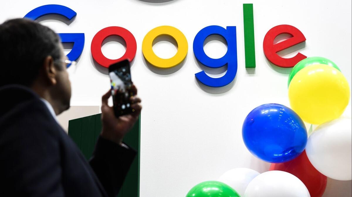 A man snaps a picture of the Google logo May 16 at the VivaTech startups and innovation fair in Paris.