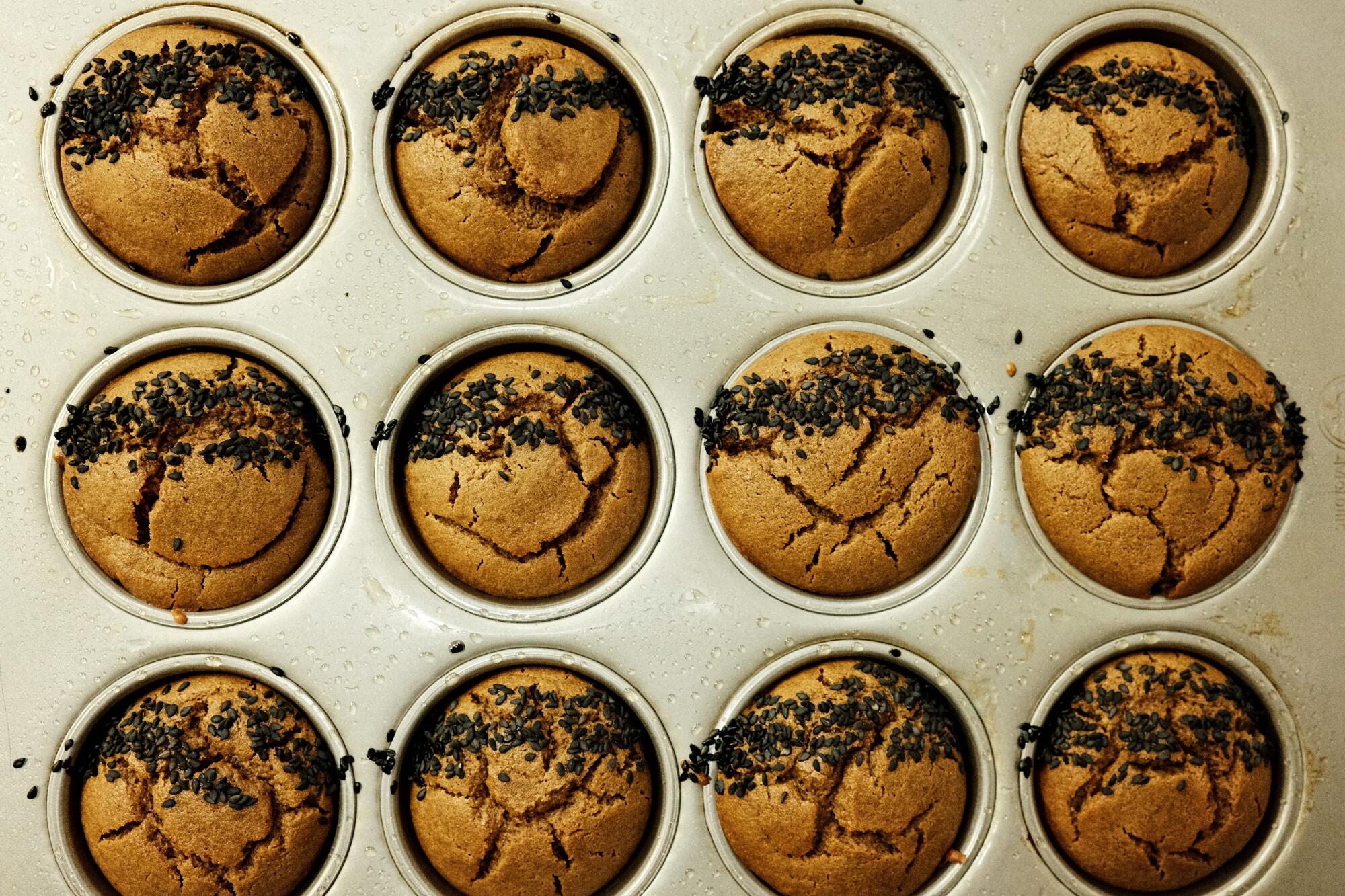 An overhead of 12 mochi muffins in a silver baking tray in the kitchen of Highland Park cafe Modu.