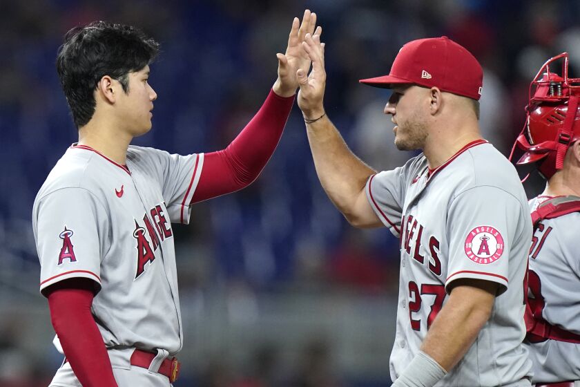 Angels pitcher Shohei Ohtani high-fives center fielder Mike Trout after beating the Marlins