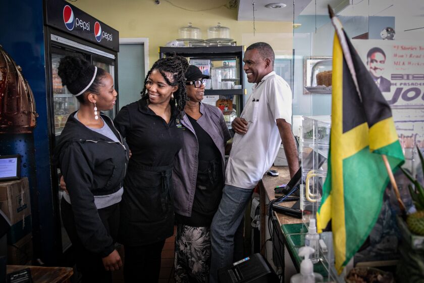 Los Angeles, CA - May 30: From Left - Sisters Melissa and Lauren Beckford pose for a portrait with their parents Marlene and Delroy at their family's restaurant, Ackee Bamboo Jamaican Cuisine in Leimert Park on Tuesday, May 30, 2023 in Los Angeles, CA. (Jason Armond / Los Angeles Times)