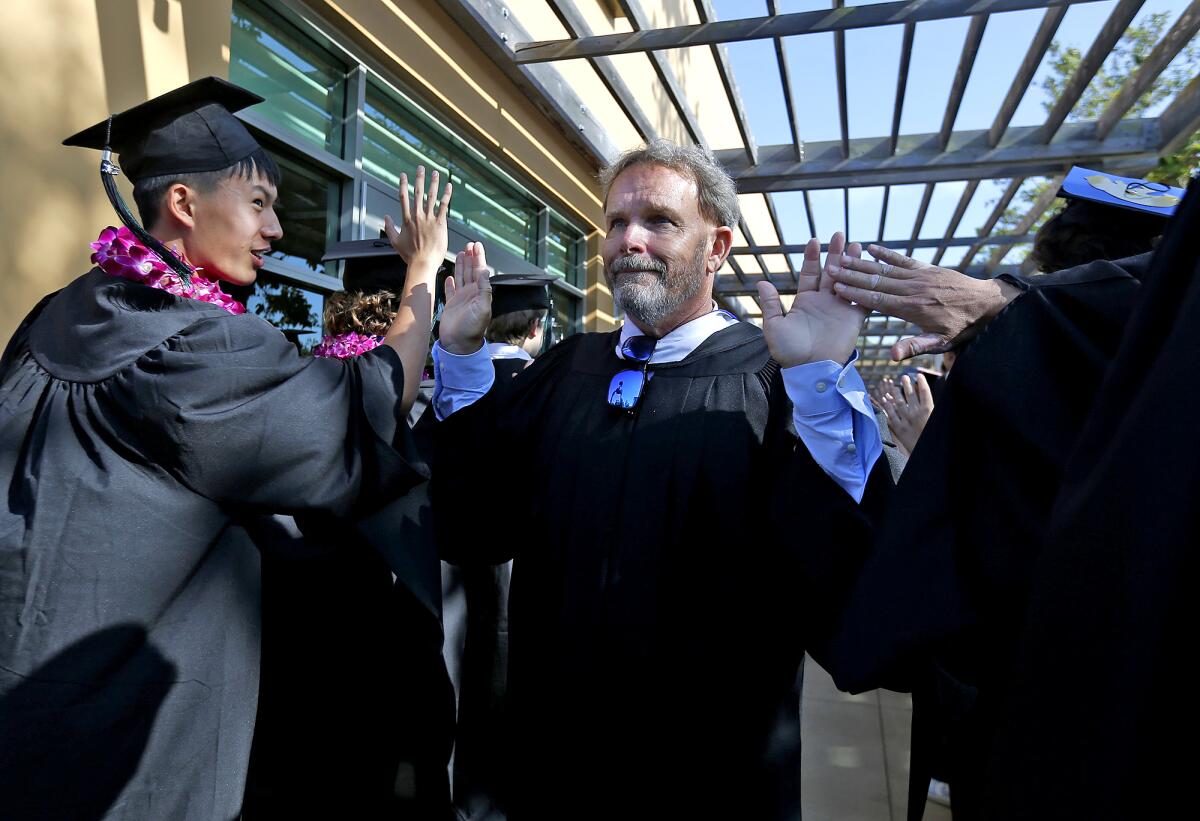 Faculty Speaker Arlie Parker gets high fives as he walks down the student tunnel.
