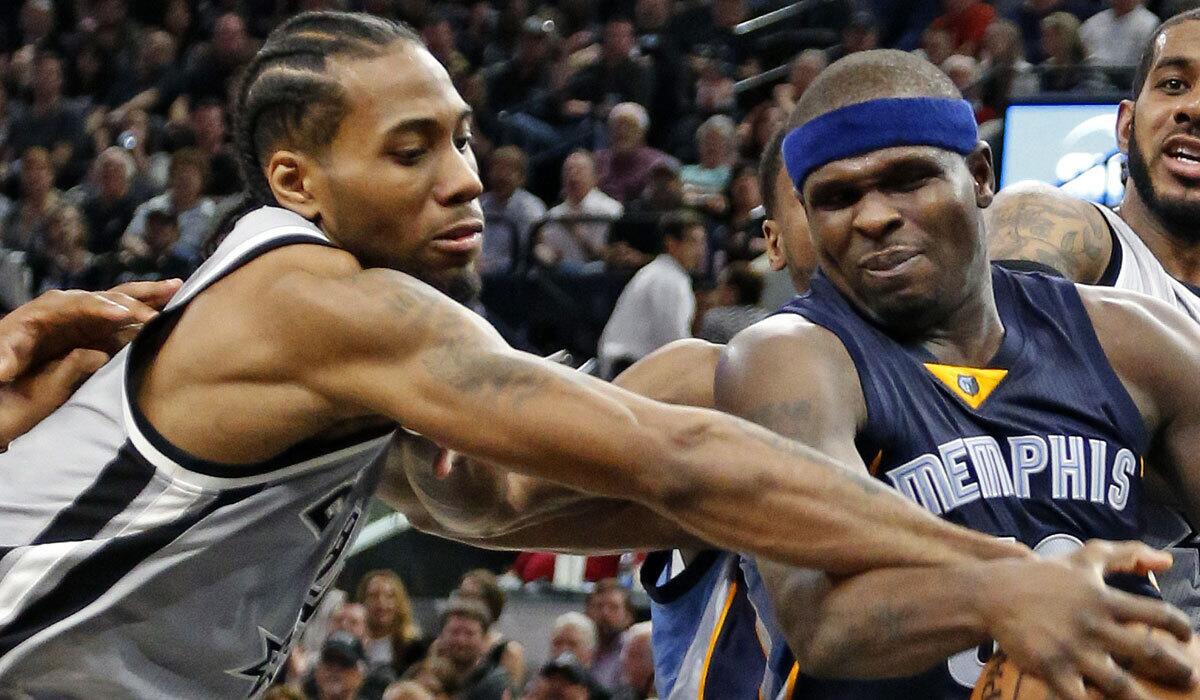 San Antonio's Kawhi Leonard, left, tries to strip the ball from Memphis' Zach Randolph on Sunday.