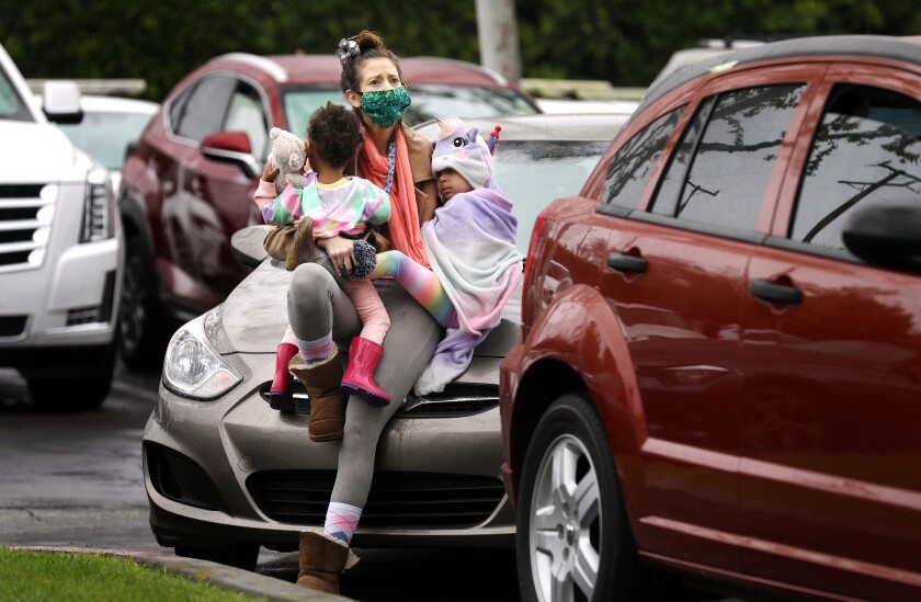 Ashley Amon and her daughters, Alysha, 2, and Alexandria, 4, who are currently homeless, attend an Easter service with fellow worshipers in their cars in a parking lot in Santa Ana.
