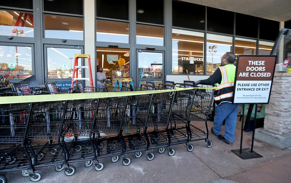 Workers replace automatic doors after a truck crashed into the Vons supermarket on Atlanta Avenue in Huntington Beach Monday.