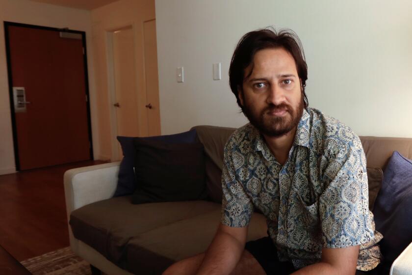 Mukesh Kulriya, a UCLA Ph.D. student in the Ethnomusicology program, sits in the living room of his apartment